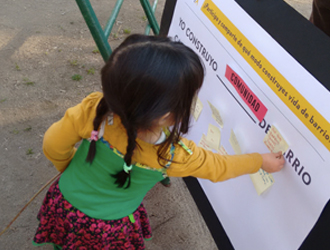 Niña participando en crear barrio